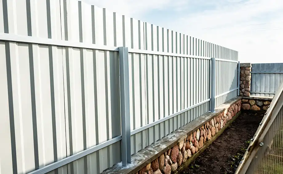 Installation eines grauen Zauns aus Metallprofilen.