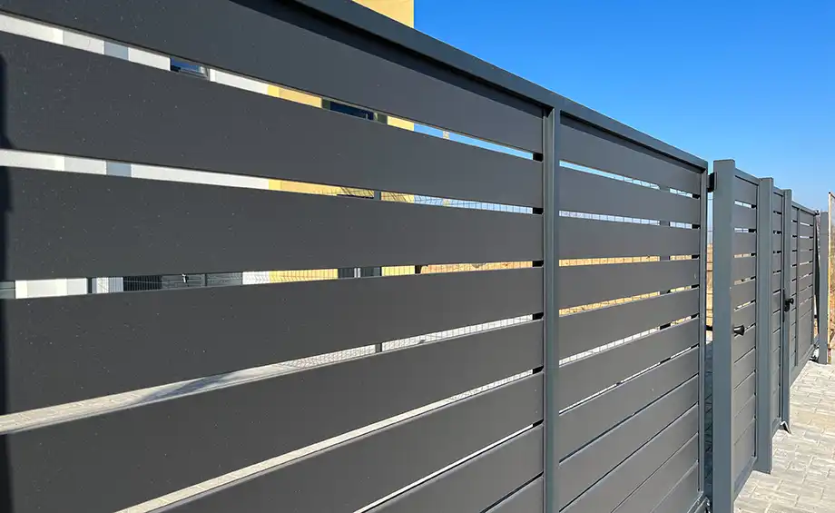 Moderner Metallzaun zur Umzäunung des Hofes. Horizontale Abschnitte des Zauns aus Metall